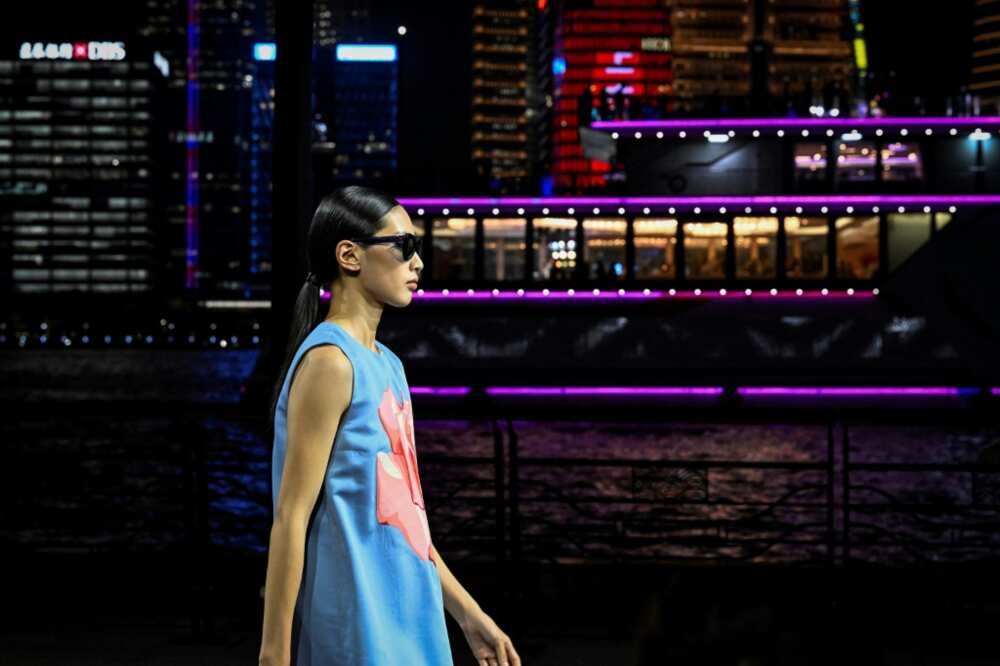 Dozens of models in dark blues and pastels paraded down the riverfront catwalk that took Shanghai's Oriental Pearl Tower as a backdrop