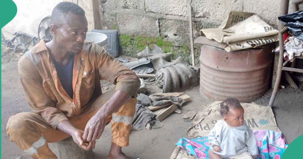 Nigerian mechanic caring for his baby.