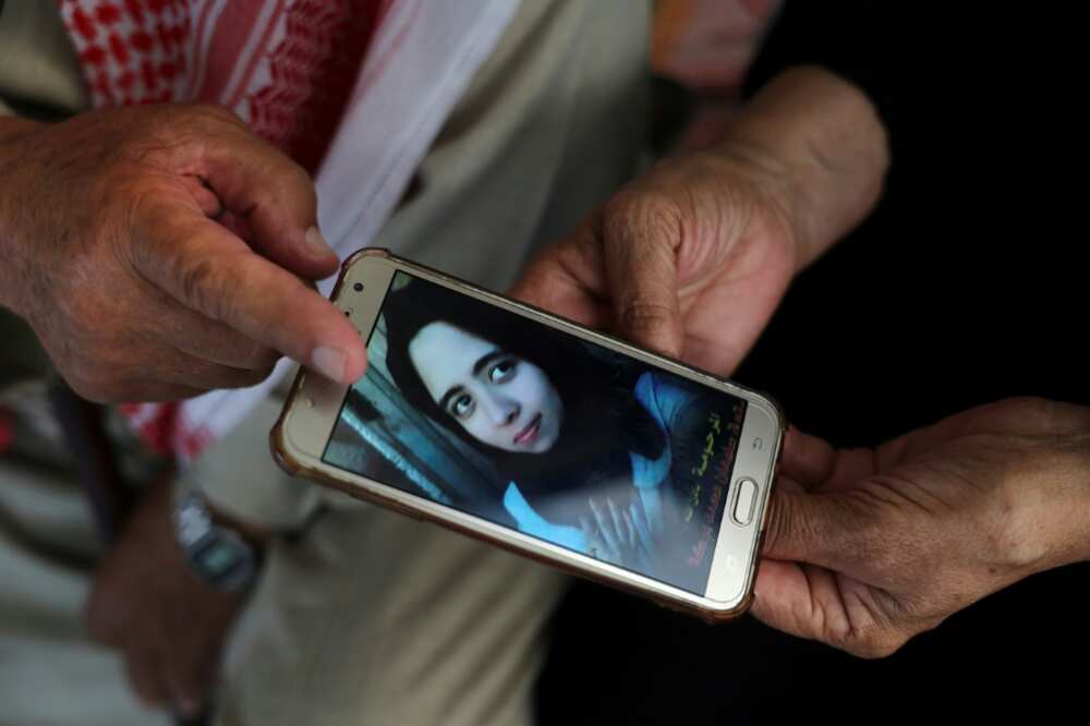 Palestinians Suleiman and Nazmiya Baraka display a picture of their daughter Istabraq, who was killed by her husband last year in the Gaza Strip