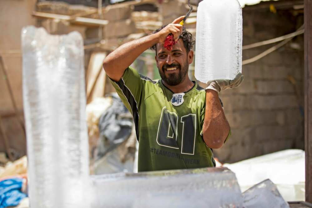 A man carries a block of ice at his stall in Iraq's southern city of Basra