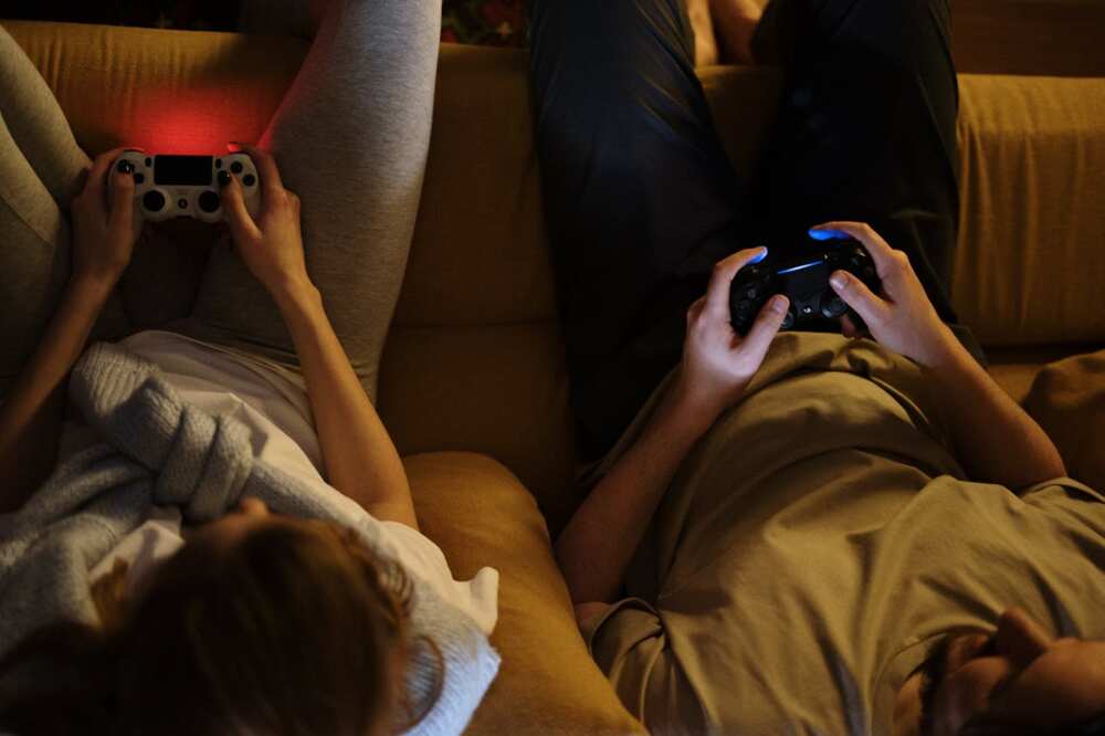 Two people gaming while holding gaming consoles in their hands