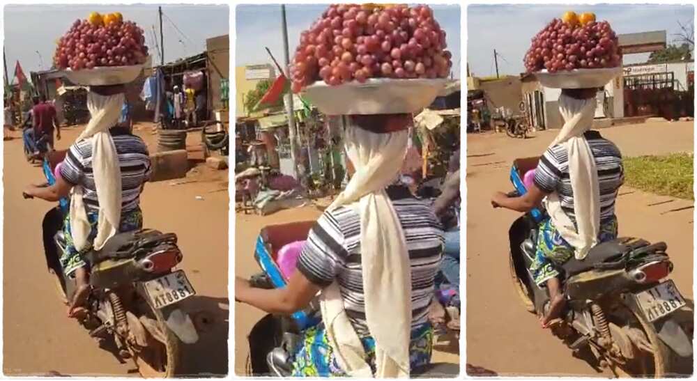 Hawker rides bike with bowl on her head.