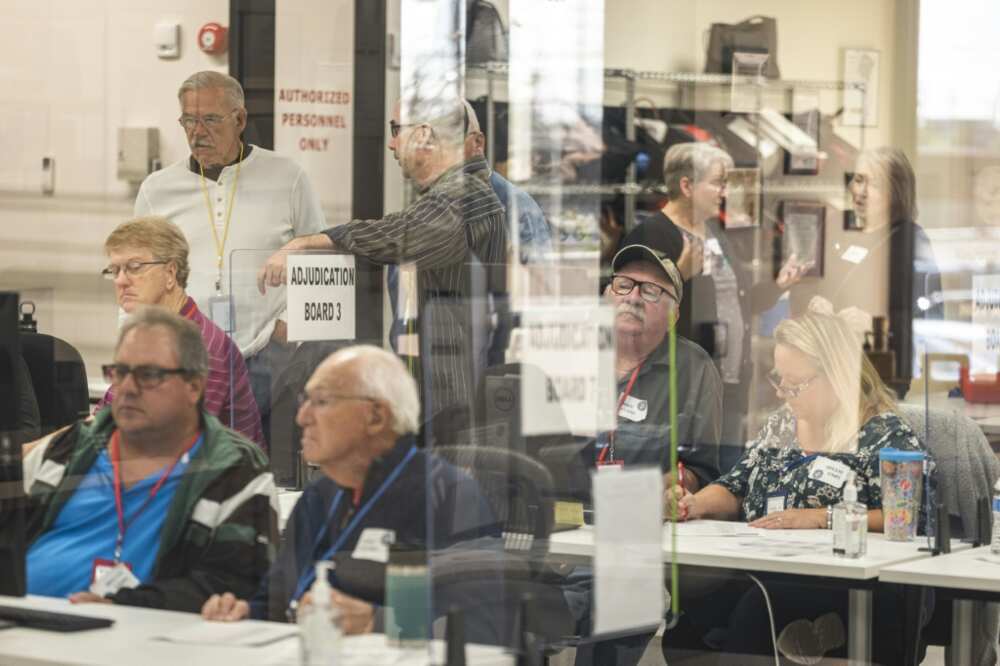 Poll workers handle ballots for the US midterm elections, in the presence of observers from both Democratic and Republican parties, at the Maricopa County Tabulation and Elections Center (MCTEC) in Phoenix, Arizona on October 25, 2022