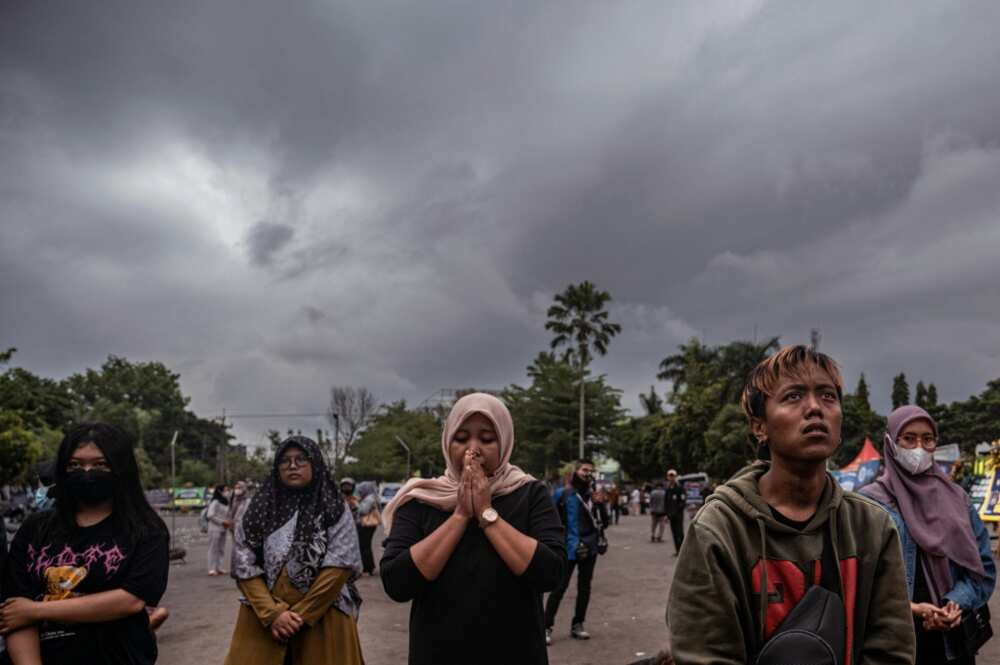 People pay their respects to the victims at Kanjuruhan stadium in Malang after a stampede that killed at least 131 people in one of the deadliest disasters in football history