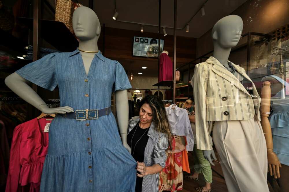 A saleswoman dresses a plus size mannequin at a store in Sao Paulo, Brazil