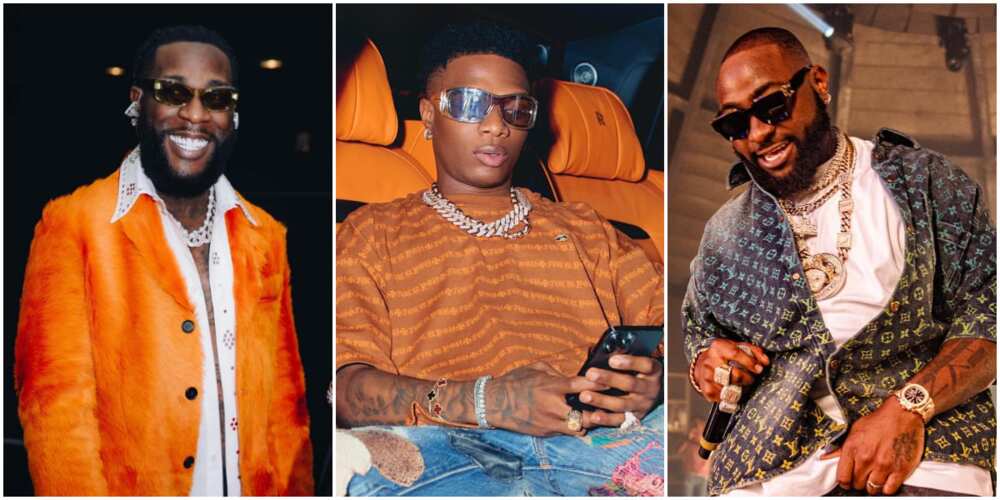 Burna Boy smiling, Wizkid, Davido on stage Burna Boy smiling, Wizkid, Davido on stage