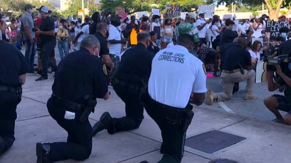 George Floyd: Solemn moment as police officers join protesters, kneel to pray