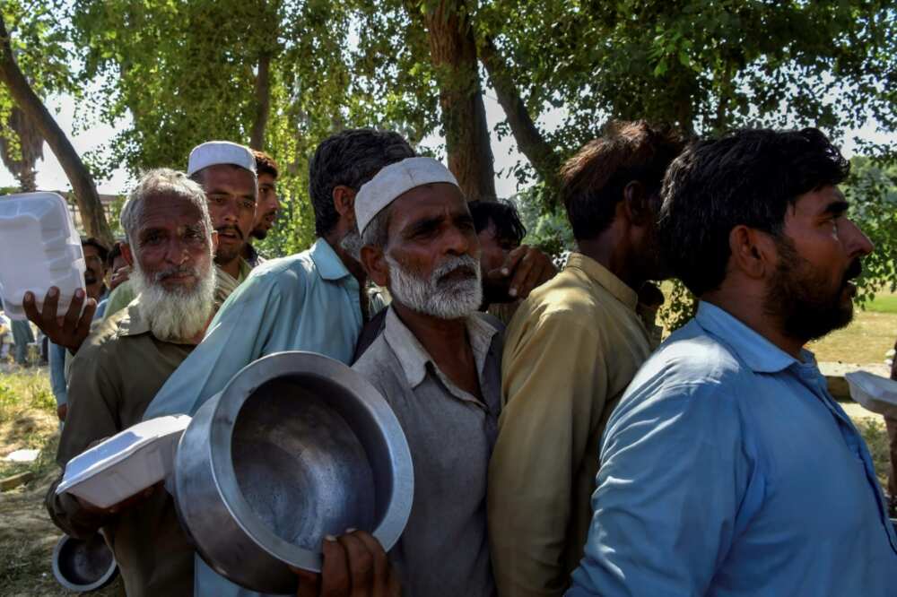 Men line up to get food for for their families at a makeshift camp in Nowshera, Pakistan