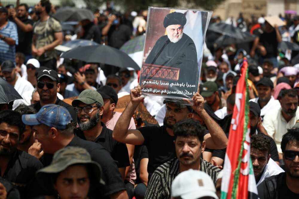 Supporters of Iraqi Shiite cleric Moqtada Sadr carry his portrait following Friday prayers outside the parliament building
