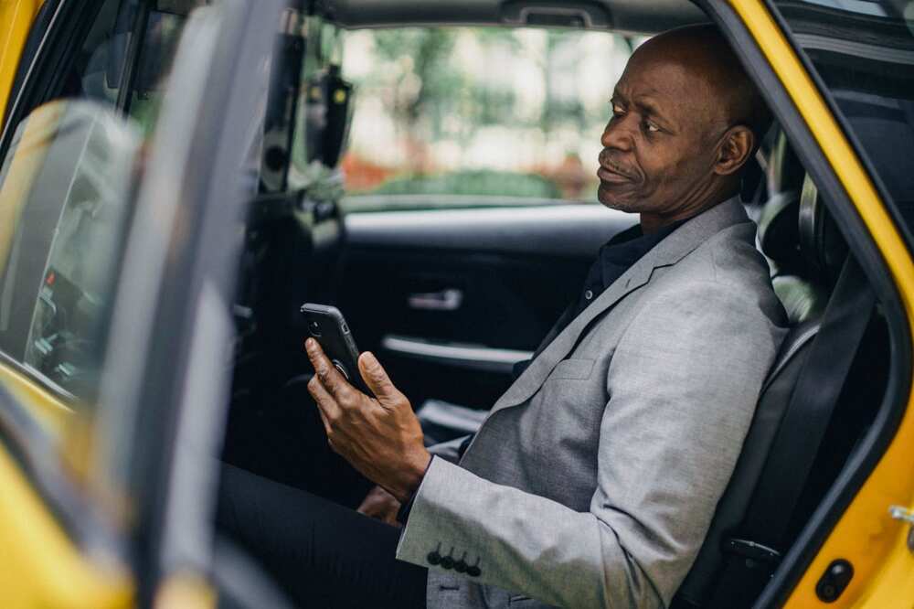 A man sitting in his car while using a phone