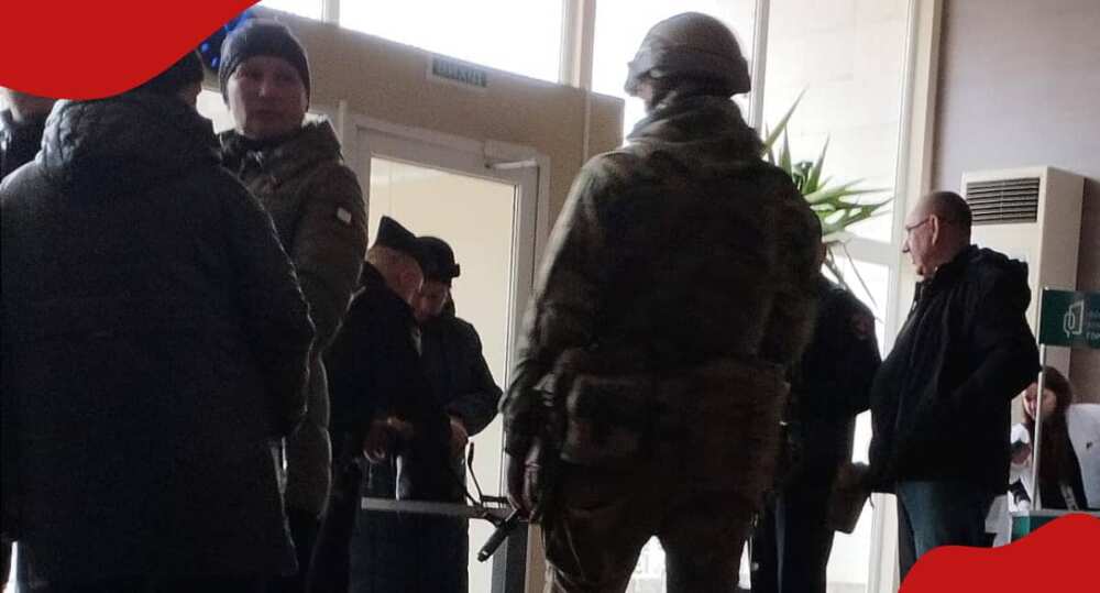 Russian servicemen stand guard during voting in occupied territories.