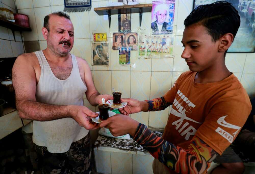 An Iraqi tea vendor prepares an order for customers in Baghdad