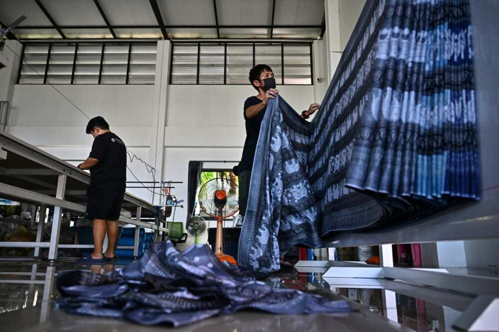 Workers in Chiang Mai prepare to cut elephant print fabric into clothing patterns