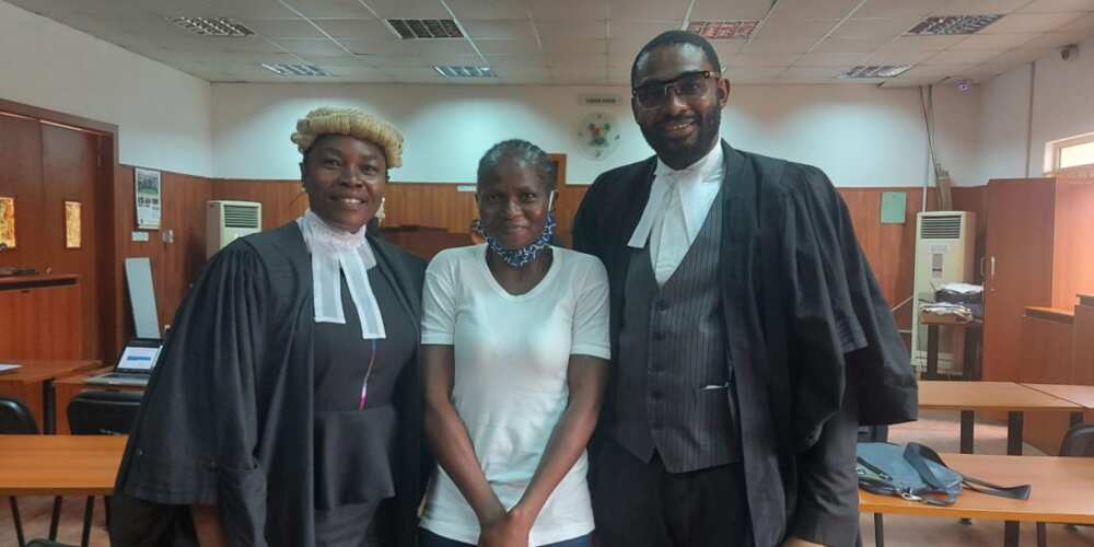 Titilayo Benson flanked by two lawyers