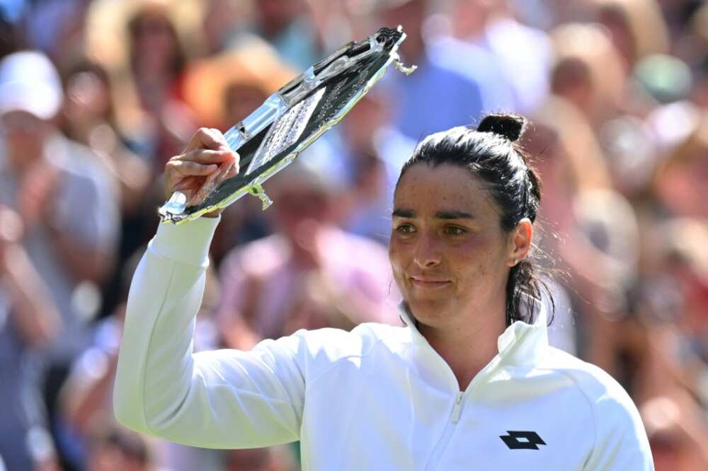 Tunisia's Ons Jabeur celebrates with her second-place trophy during the podium ceremony after loosing against Kazakhstan's Elena Rybakina in their Wimbledon final