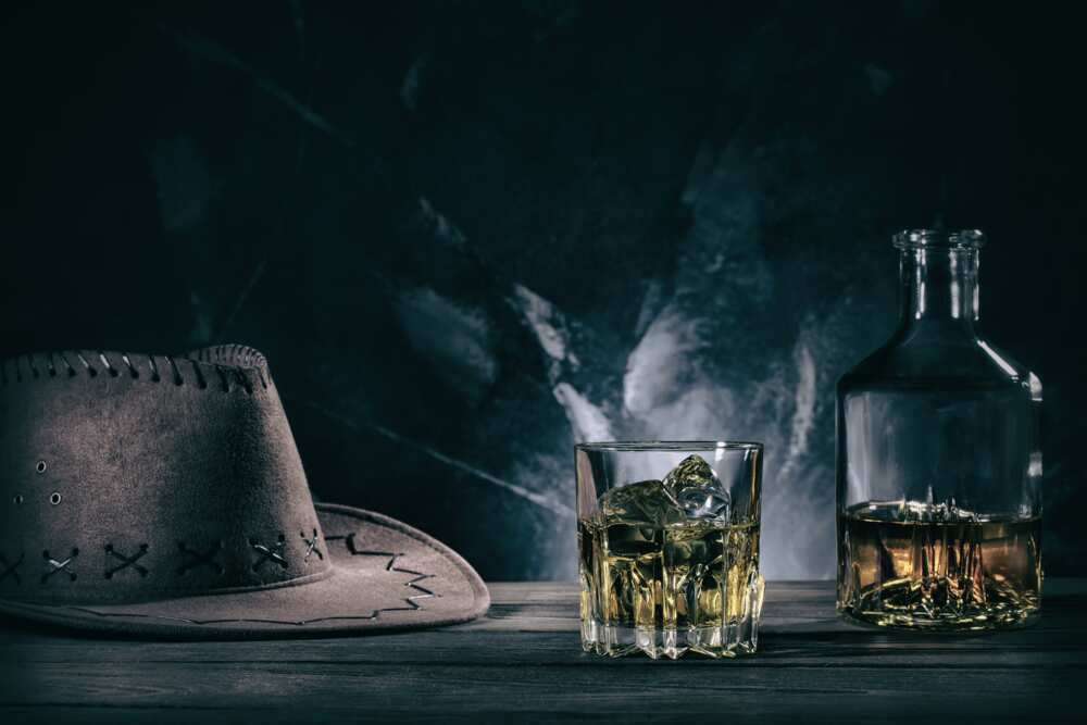 Glass oh whiskey and cowboy hat