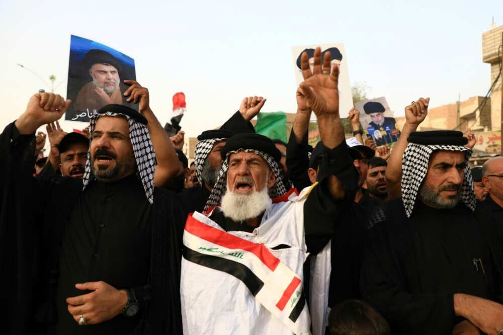 Supporters of Shiite cleric Moqtada Sadr carry portraits of him as they gather in the city of Nasiriyah in Iraq's southern Dhi Qar province