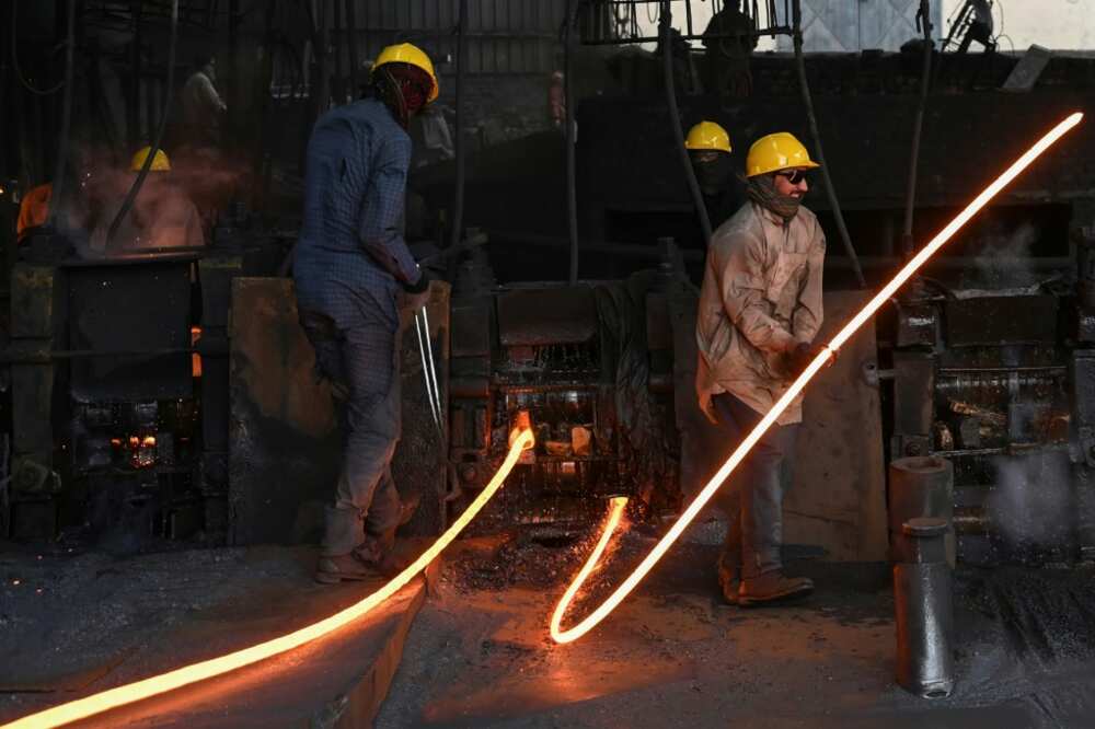 Labourers mould molten steel rods at a mill in Islamabad