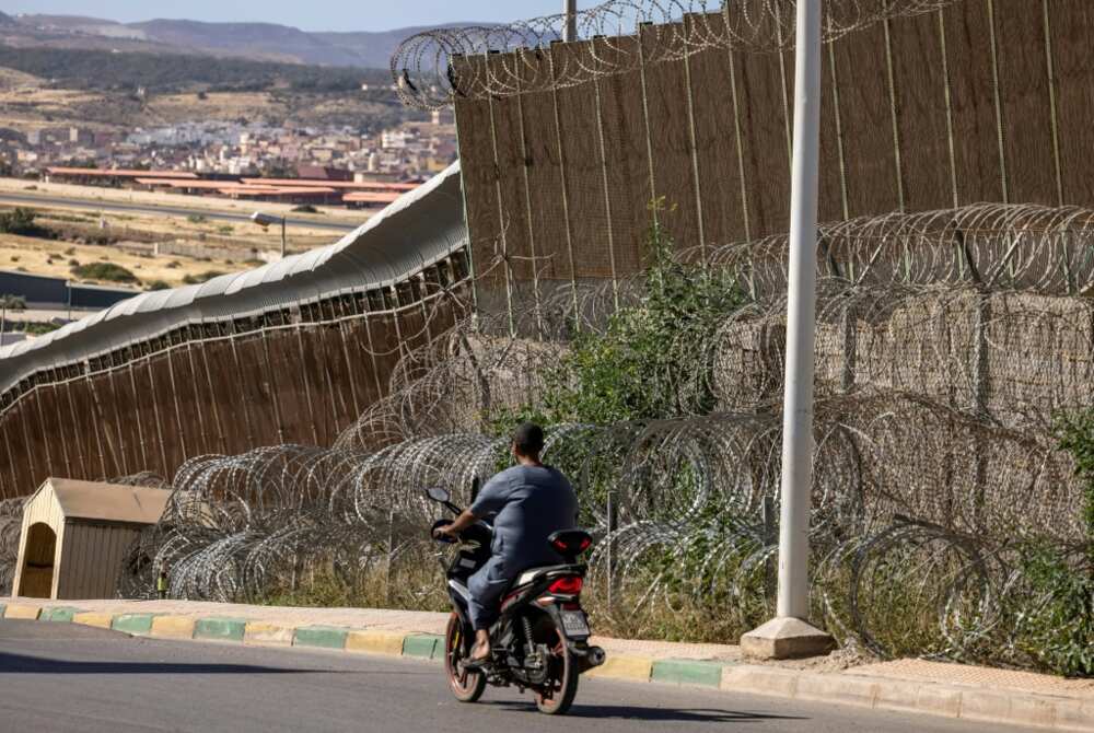 A man rides a motorbike along the border fence separating Morocco and Spain's North African enclave of Melilla