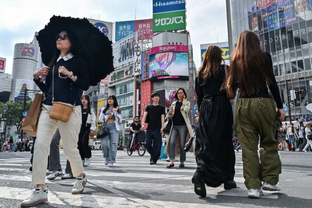 Pedestrians cross the intersection at Shibuya Crossing in Tokyo