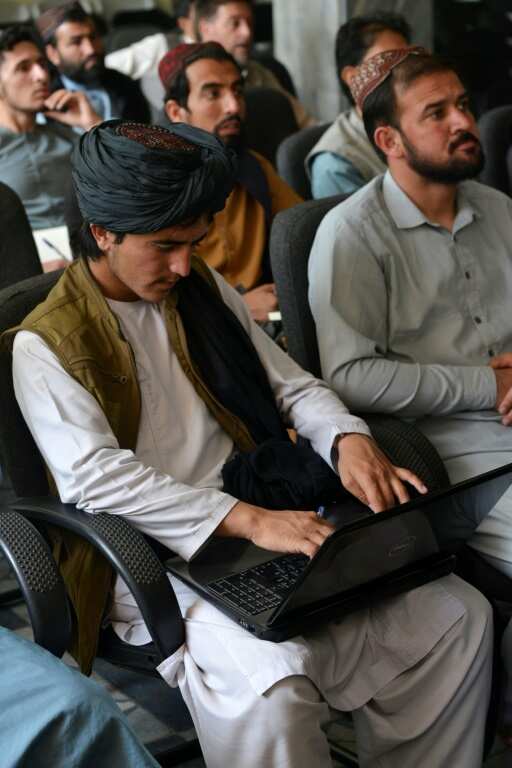 A Taliban member (L) attends a computer science class in Kabul