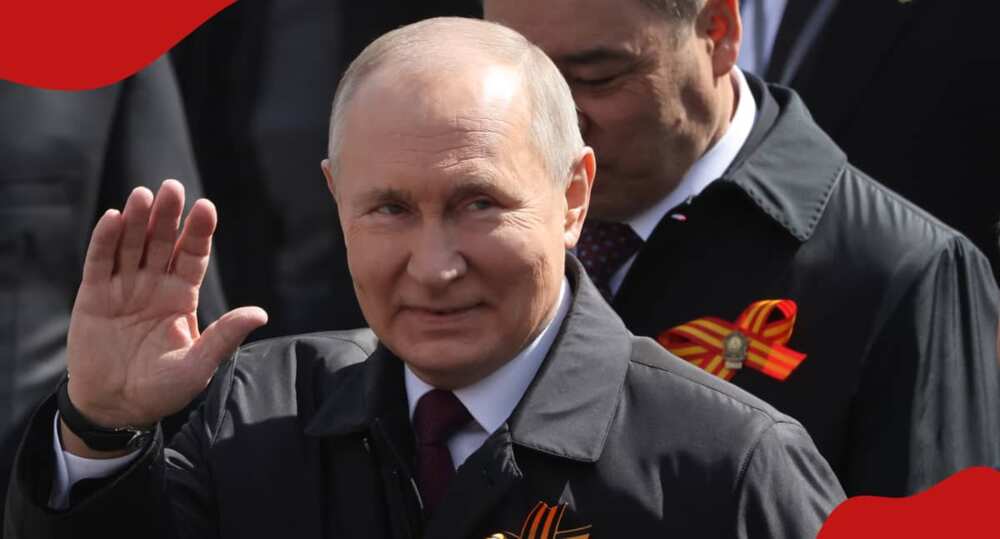Russian president Vladimir Vladimirovich Putin waving at supporters.