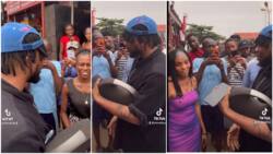 People gather around man in UNIBEN as he sings about them, approaches lady, 'toasts' her with music in video