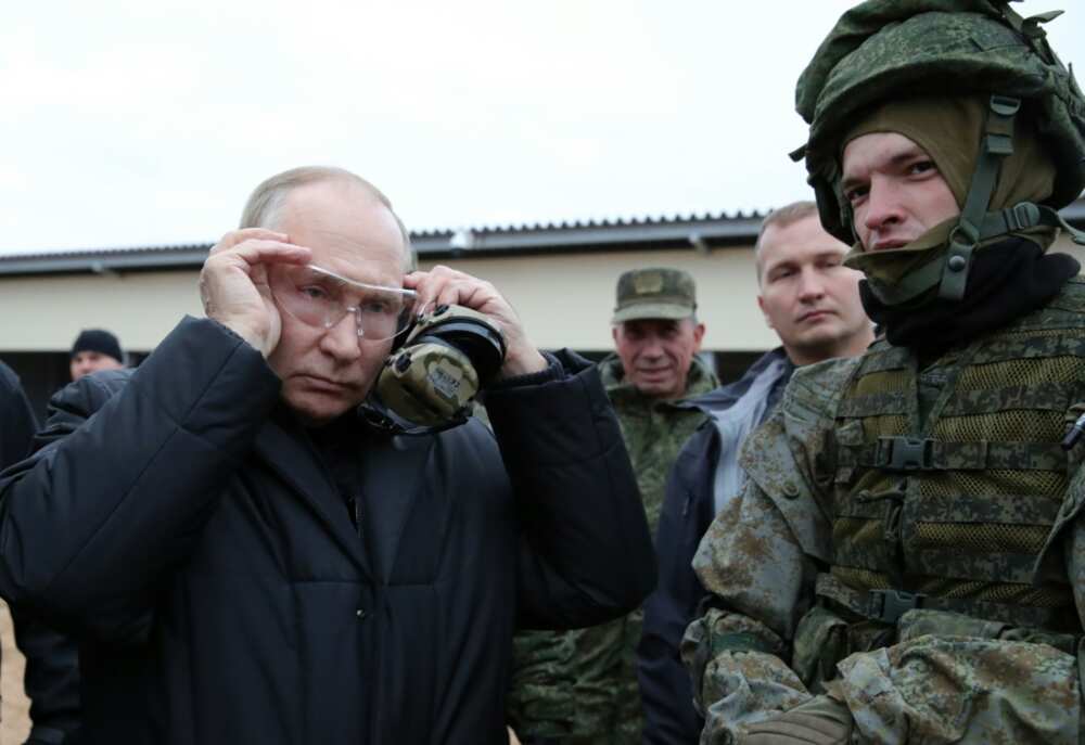 Russian President Vladimir Putin (L) meets soldiers during a visit at a military training centre of the Western Military District for mobilised reservists, outside the town of Ryazan on October 20, 2022.