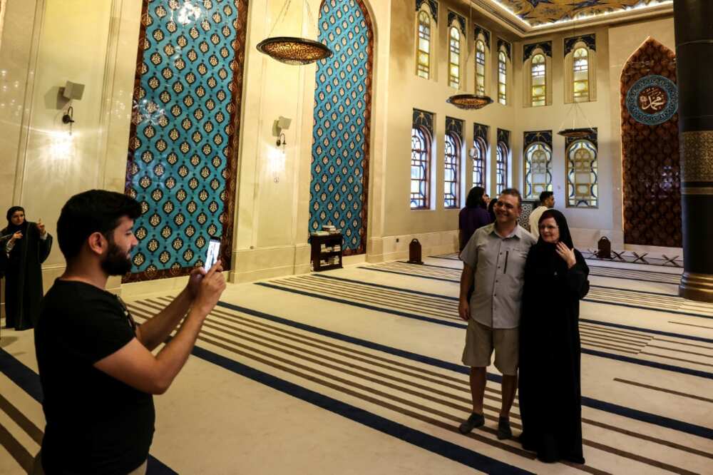 Canadian couple Dorinel and Clara Popa pose for a picture inside Doha's Blue Mosque