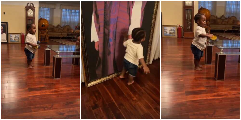 Heir apparent: Davido proudly shows off Ifeanyi as he plays and admires photos in his grandfather's house