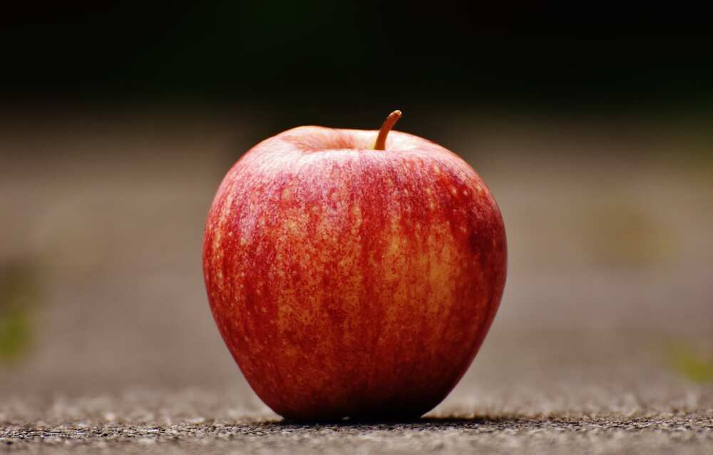 An apple on a grey surface