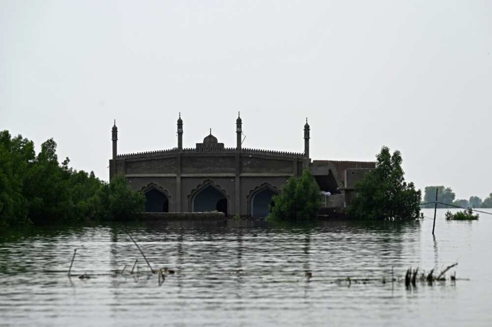 The single road leading to Basti Ahmad Din is submerged, leaving boats as the only way in or out