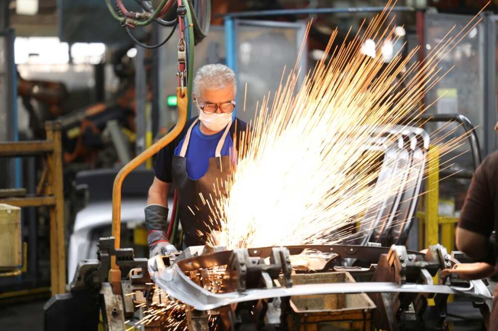 Technicians work on Peugeot 207 and 206 car production lines at the Iran Khodro plant on August 14, 2022
