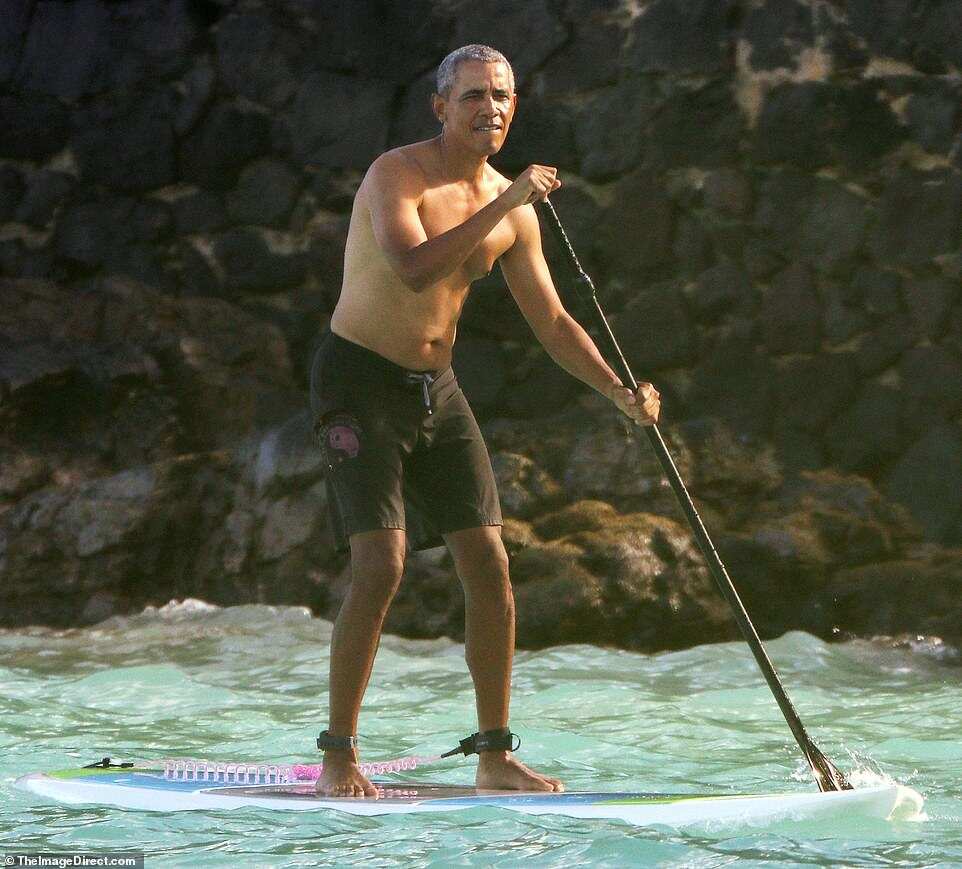 Barack Obama goes paddleboarding shirtless in Hawaii in $84 shark deterrent ankle band