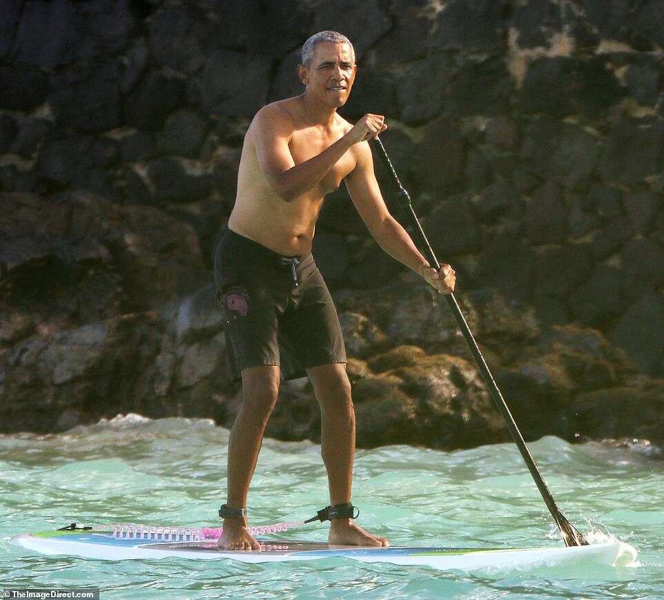 Barack Obama goes paddleboarding shirtless in Hawaii in $84 shark deterrent ankle band Barack Obama goes paddleboarding shirtless in Hawaii in $84 shark deterrent ankle band