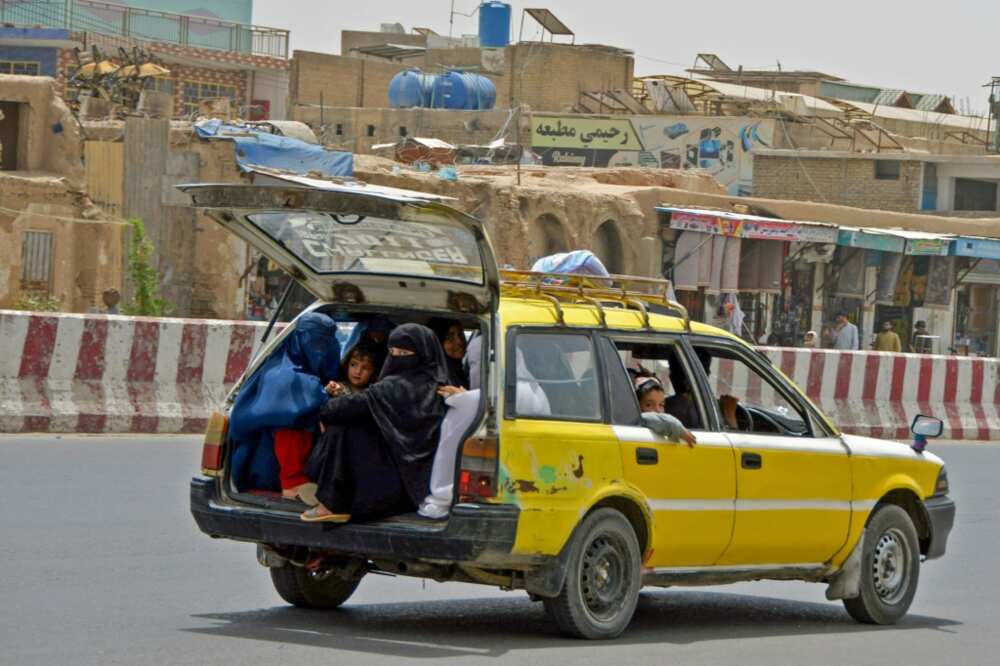 Afghan women and children commute in the back of a taxi in Kandahar