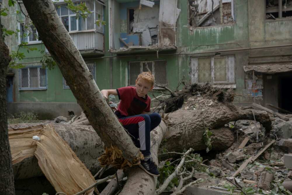 A boy sizes up the damage after a Russian strike in  
Kostiantynivka, eastern Ukraine