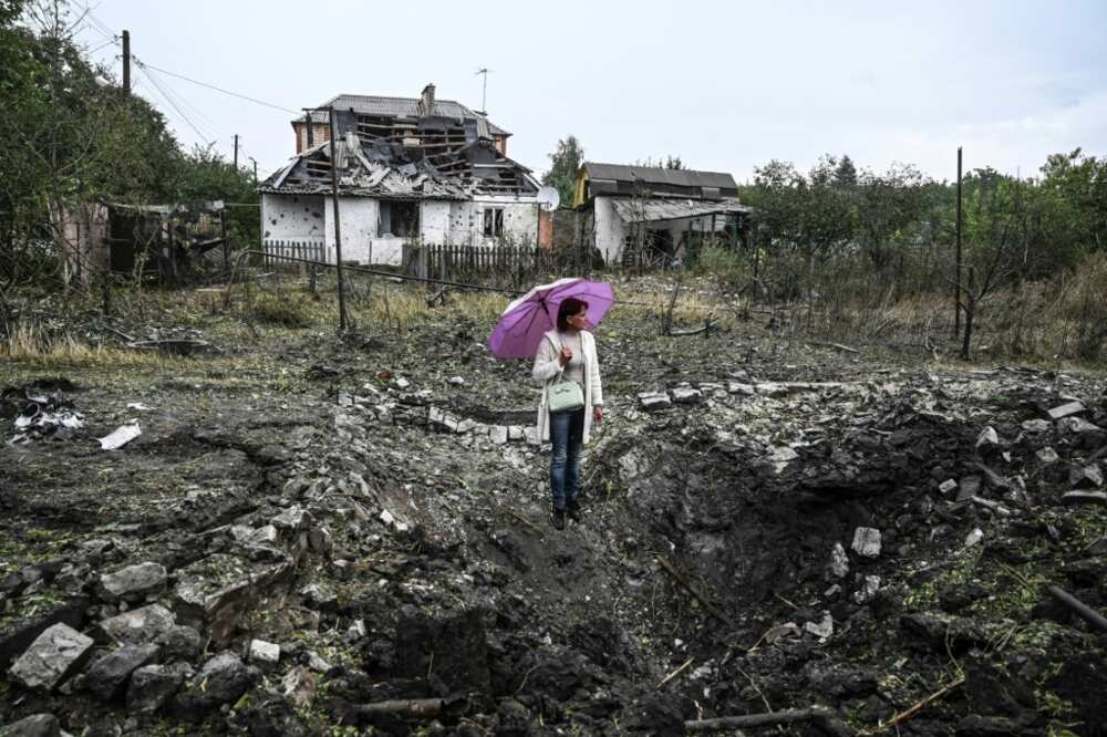 A woman stands in front of a destroyed house, in Kramatorsk, Donetsk region, on September 12, 2022