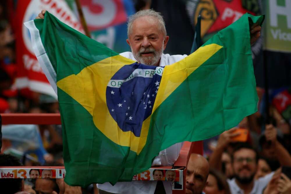 Brazil's former president Luiz Inacio Lula da Silva holds a Brazilian national flag during a re-election campaign rally in Guarulhos, Sao Paulo state, Brazil in October  2022