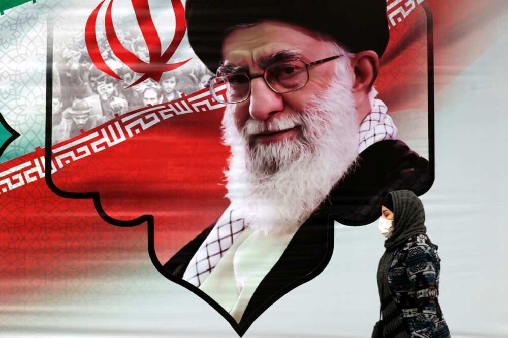 An Iranian woman walks past a billboard showing the supreme leader Ayatollah Ali Khamenei in the capital Tehran