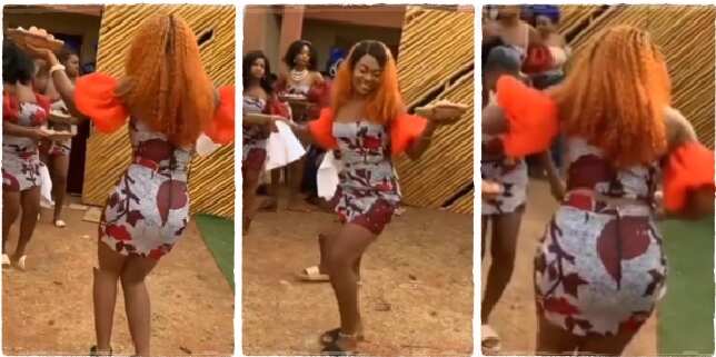 A Nigerian lady in short Ankara gown with basket in her hands danced very nicely at an Igbo traditional wedding, stealing the show