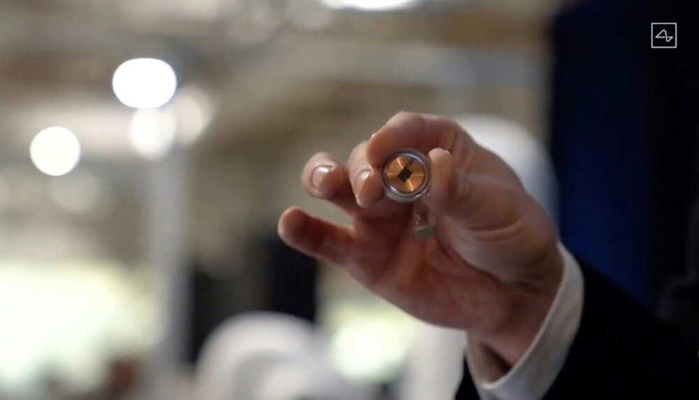 A Neuralink disk implant held by Elon Musk A Neuralink disk implant held by Elon Musk