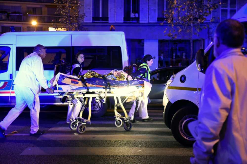 Rescuers evacuate a victim close to the Bataclan following the attack on November 13, 2015