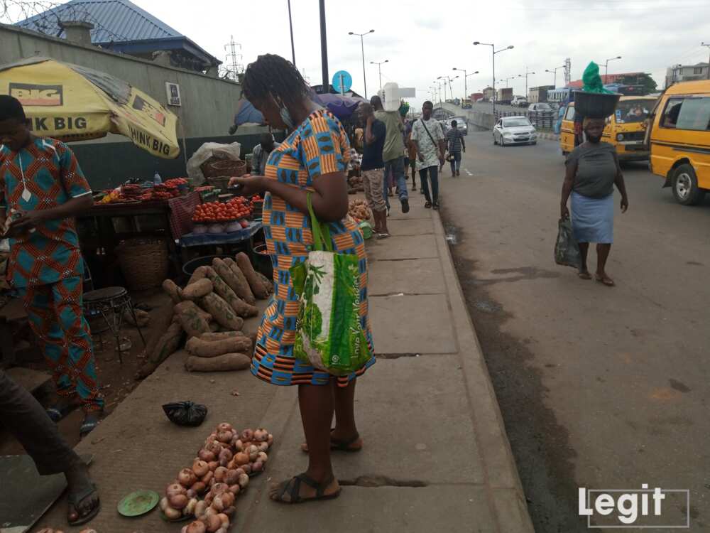 A buyer, checking out the cost price of onion on display at a market in Lagos state. Photo credit: Esther Odili