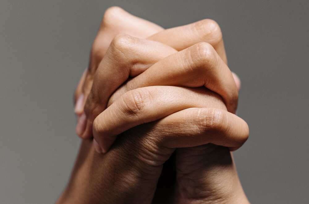 A close up photo of clasped hands