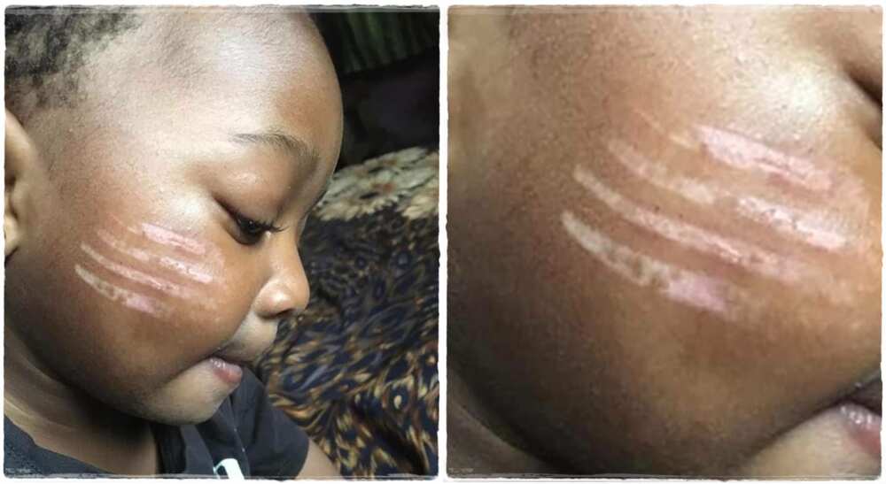 Child given tribal marks by a teacher.