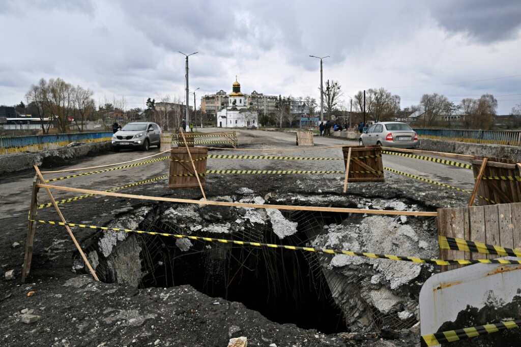 Mother weeps by roadside grave on route of Russian retreat