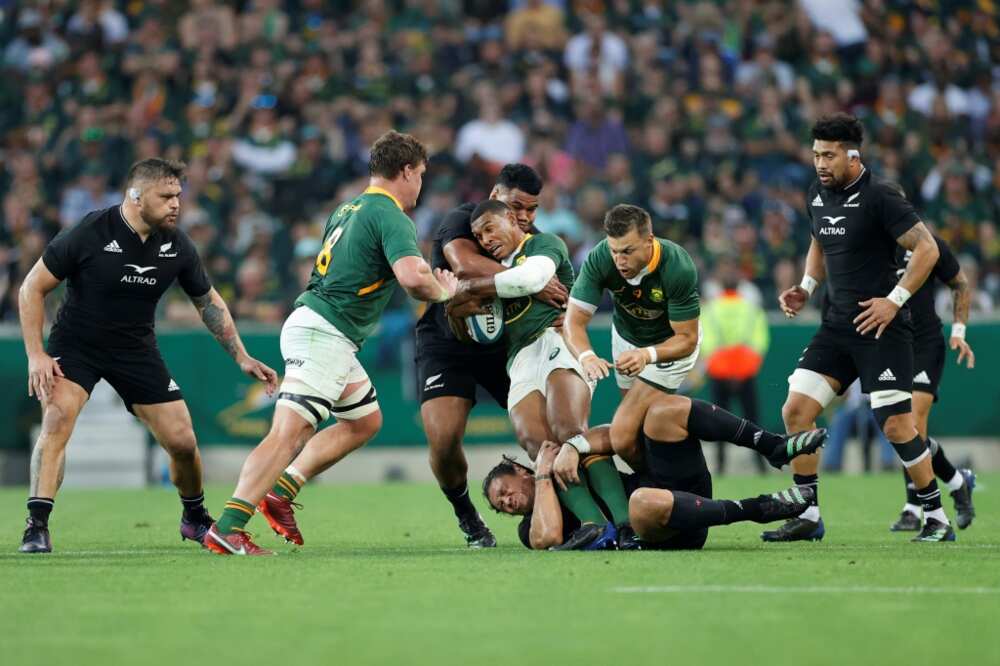 South Africa's fullback Damian Willemse (C) is tackled by New Zealand's wing Caleb Clarke (bottom) and New Zealand's hooker Samisoni Taukei'aho (3rd L) during the Rugby Championship international rugby match between South Africa and New Zealand at the Mbombela Stadium in Mbombela on August 6, 2022.