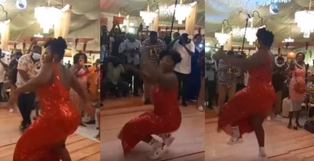 Female wedding guest in long one-armed dress dances with intense energy, people stand up for her in video