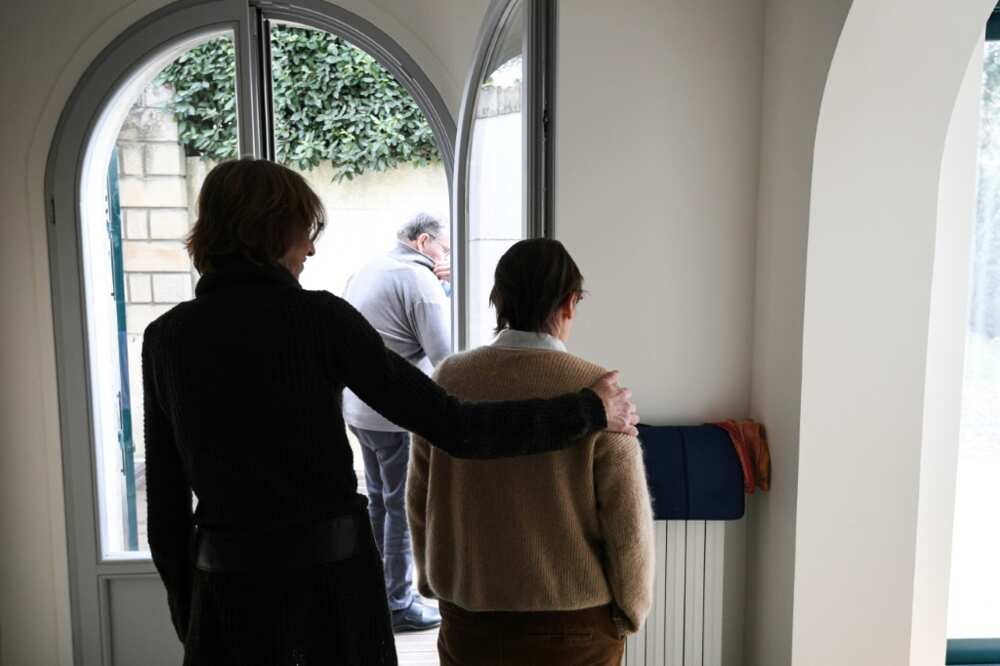 A carer helps an elderly resident - one of three alzheimer sufferers in the establishment- in a house at L'Hay-les- Roses on the outskirts of Paris